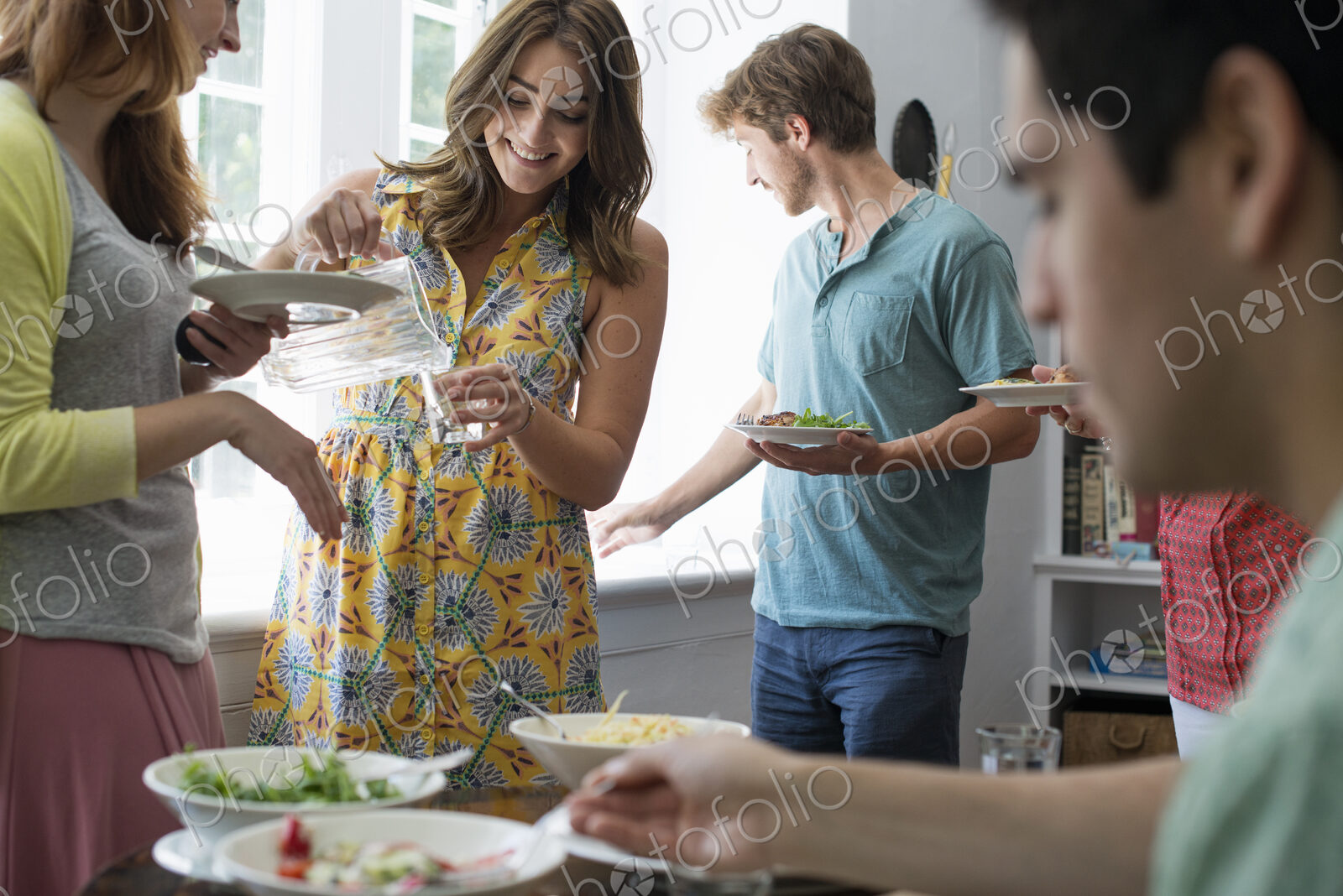 A family gathering for a meal. Adults and children around a table.