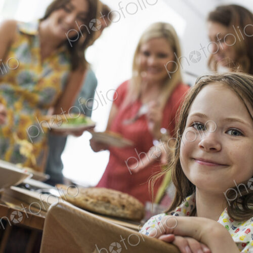 A family gathering for a meal. Adults and children around a table.