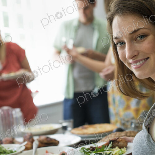 A family gathering for a meal. Adults and children around a table.
