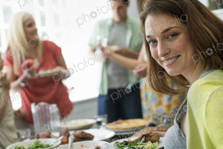 A family gathering for a meal. Adults and children around a table.