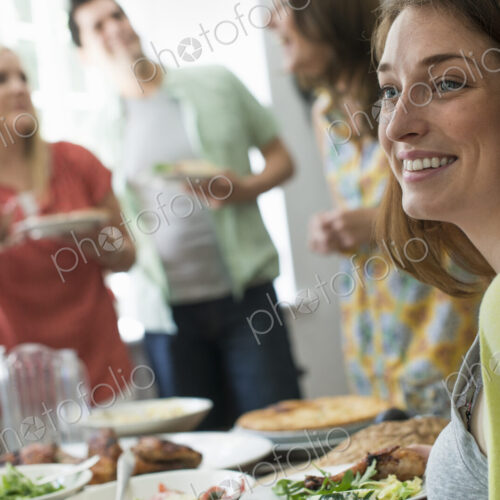 A family gathering for a meal. Adults and children around a table.