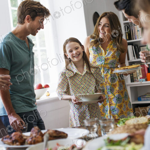 A family gathering for a meal. Adults and children around a table.