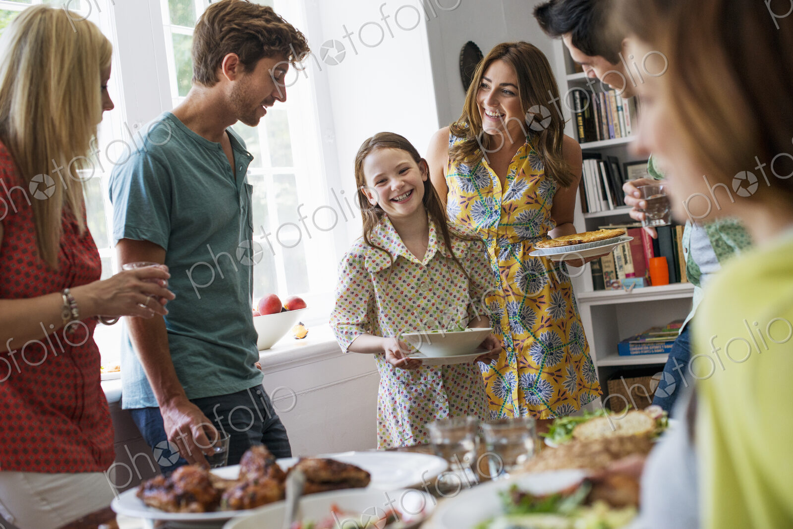 A family gathering for a meal. Adults and children around a table.