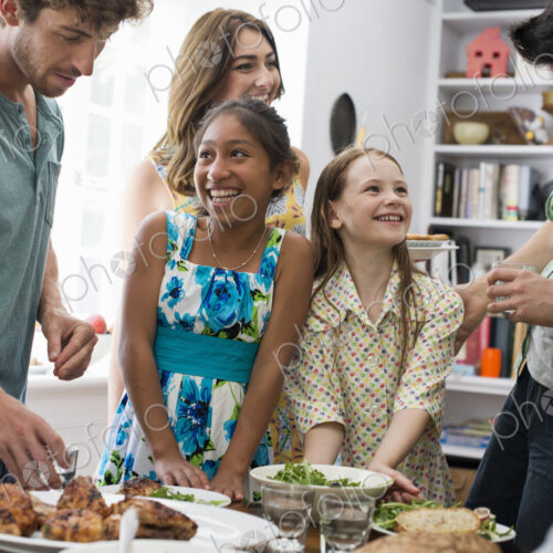 A family gathering for a meal. Adults and children around a table.
