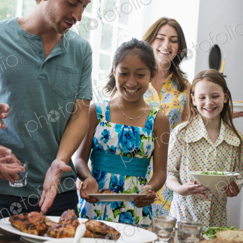 A family gathering for a meal. Adults and children around a table.