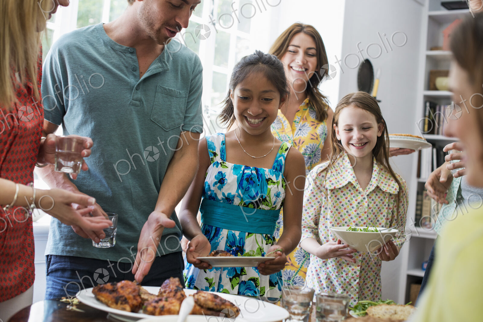 A family gathering for a meal. Adults and children around a table.