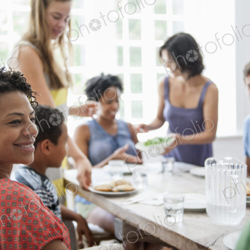 A family gathering for a meal. Adults and children around a table.
