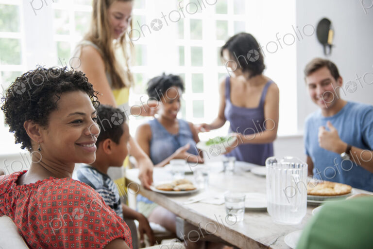 A family gathering for a meal. Adults and children around a table.