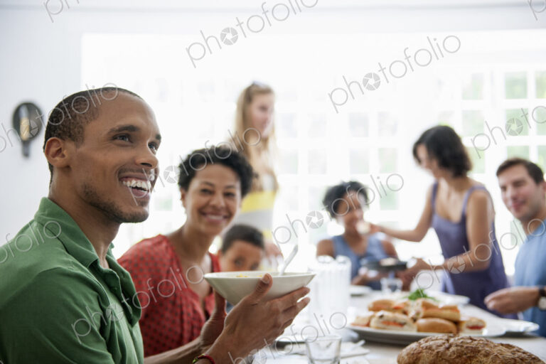 A family gathering for a meal. Adults and children around a table.