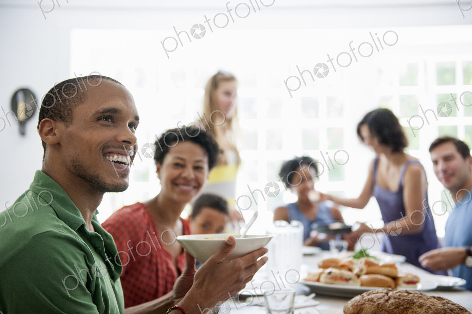 A family gathering for a meal. Adults and children around a table.