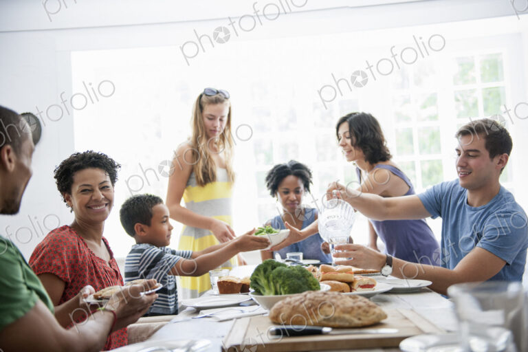 A family gathering for a meal. Adults and children around a table.