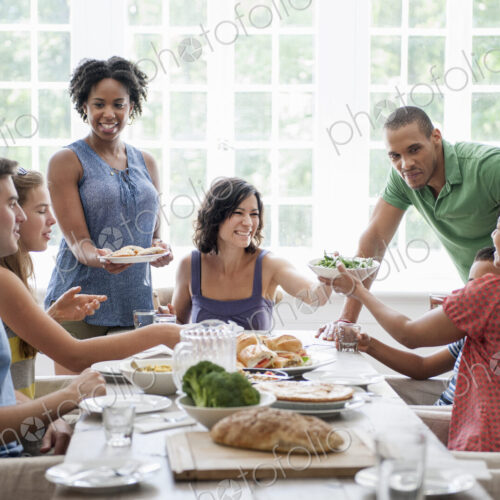 A family gathering for a meal. Adults and children around a table.