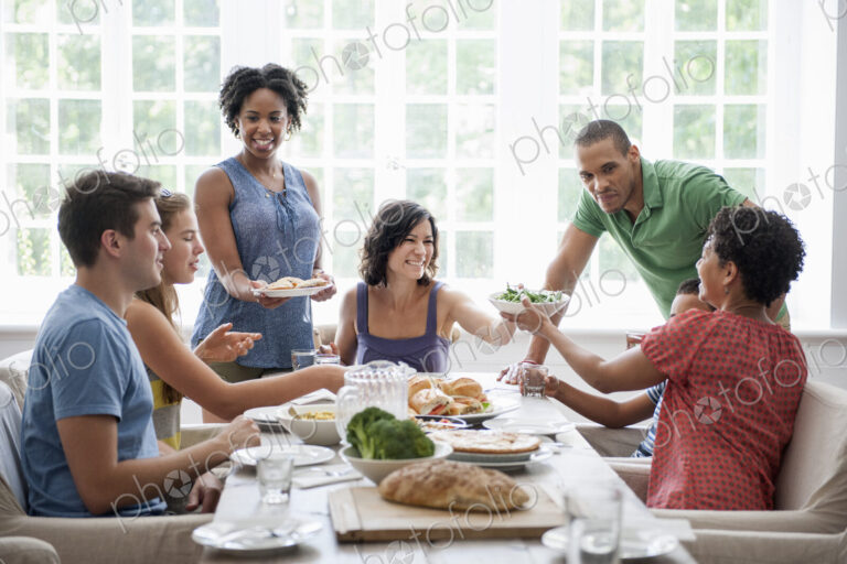 A family gathering for a meal. Adults and children around a table.