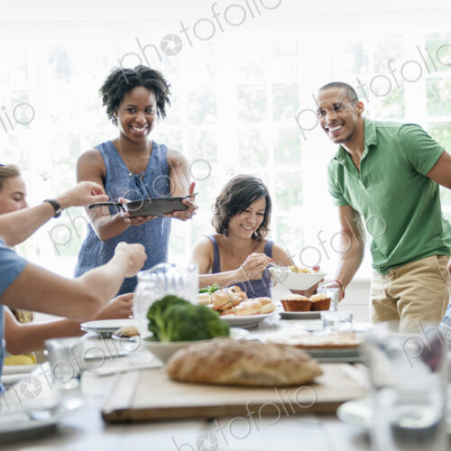 A family gathering for a meal. Adults and children around a table.