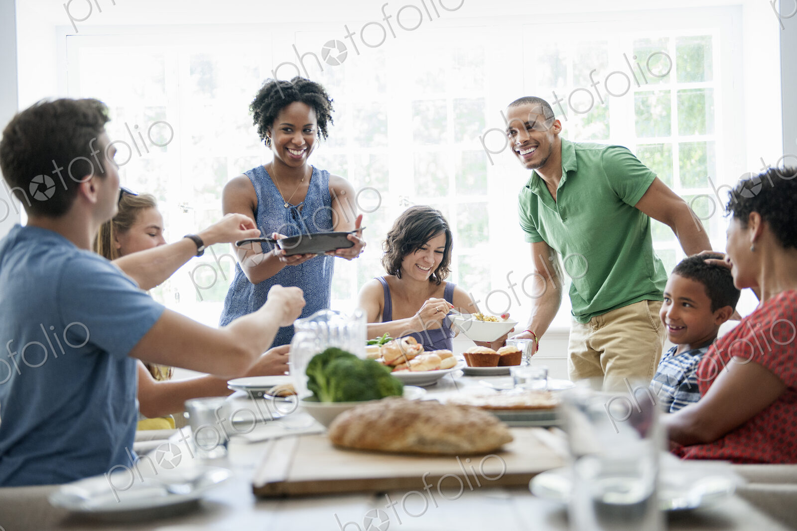 A family gathering for a meal. Adults and children around a table.