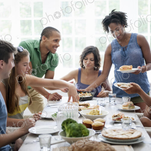 A family gathering for a meal. Adults and children around a table.
