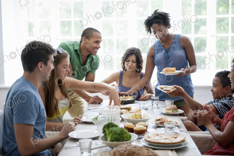 A family gathering for a meal. Adults and children around a table.
