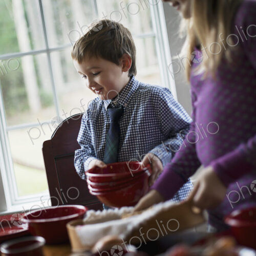 A family home. Two children laying the table with crockery for a meal. A family home. Two children laying the table with crockery for a meal.