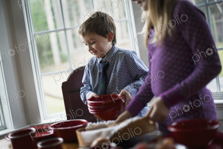 A family home. Two children laying the table with crockery for a meal.