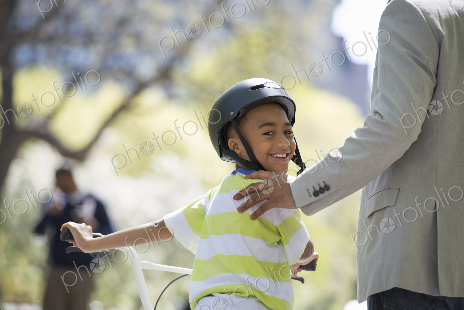 A family in the park on a sunny day. Bicycling and having fun. A father and son side…