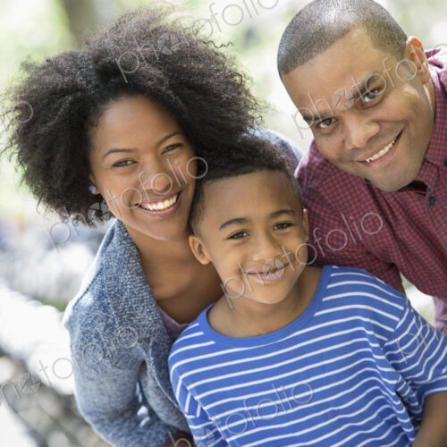 A family in the park on a sunny day. Two adults and a young boy taking photographs… A family in the park on a sunny day. Two adults and a young boy taking photographs…