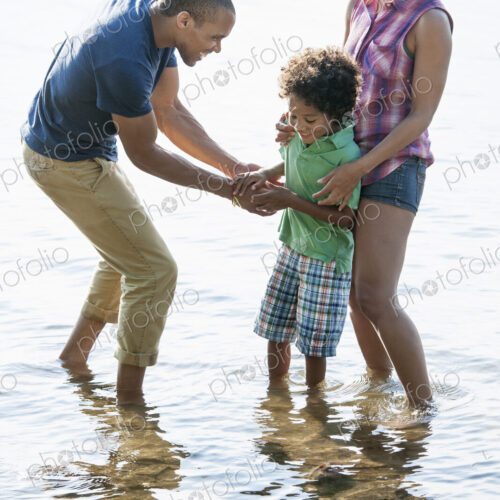 A family, mother, father and son playing on the shores of a lake. A family, mother, father and son playing on the shores of a lake.