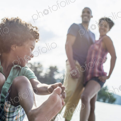 A family, parents and son spending time together by a lake in summer. A family, parents and son spending time together by a lake in summer.
