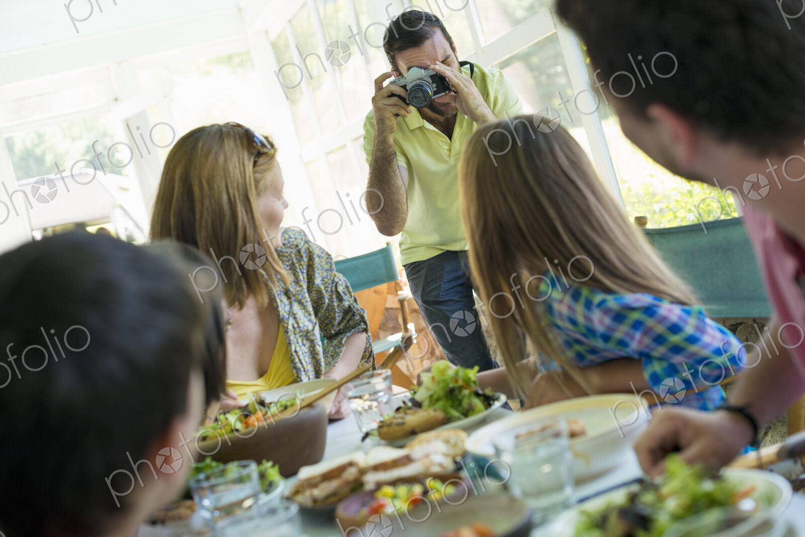 A family party around a table in a cafe. Adults and children.