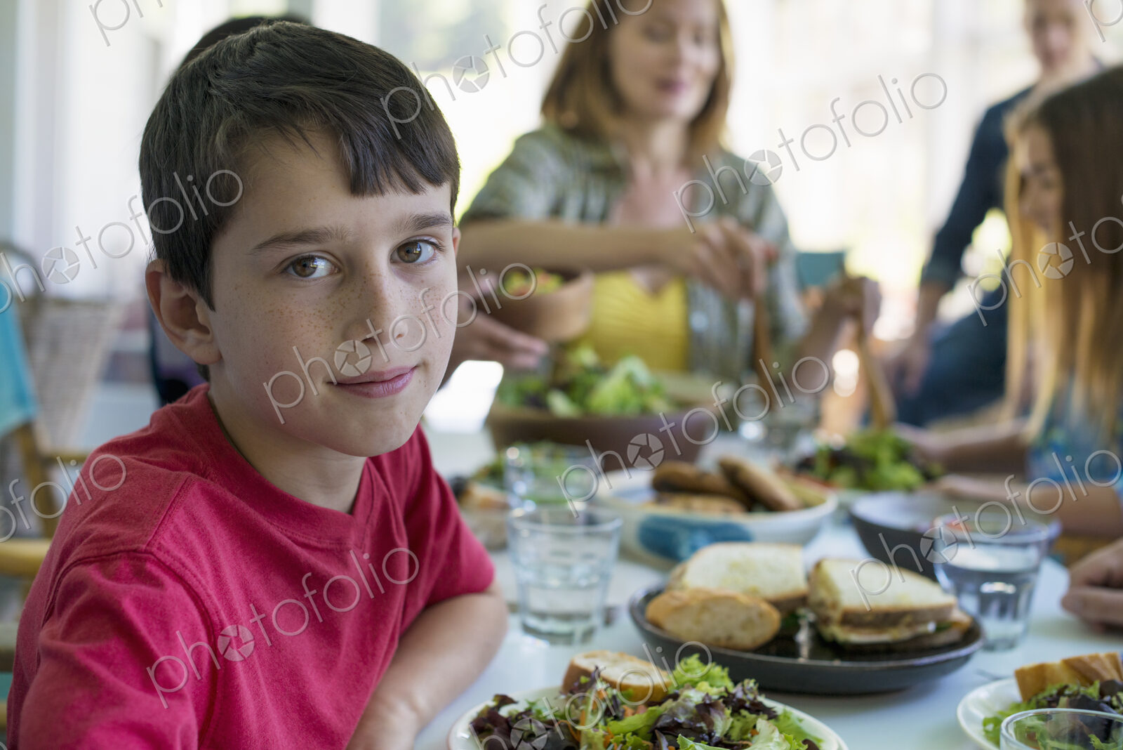 A family party around a table in a cafe. Adults and children.