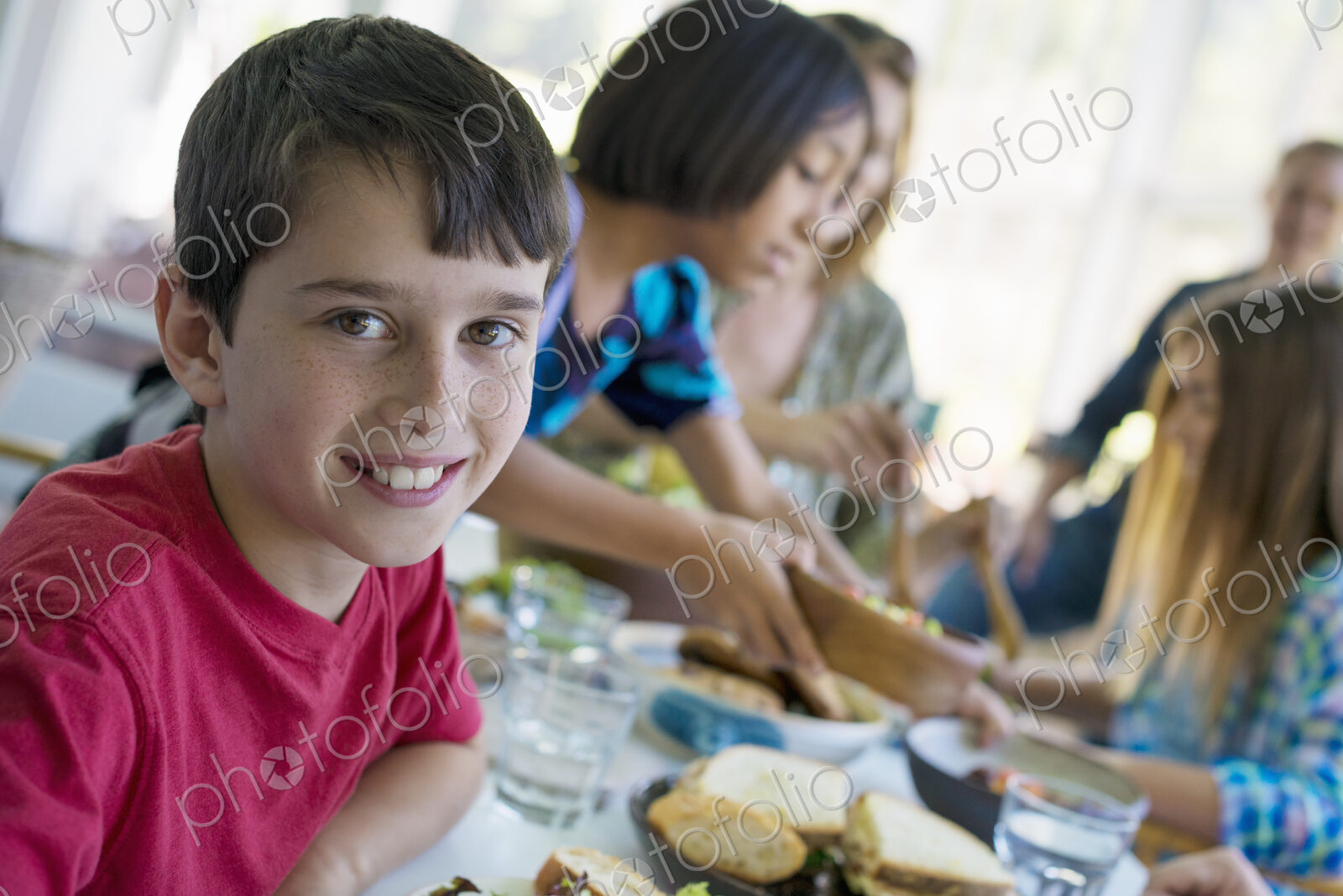 A family party around a table in a cafe. Adults and children.