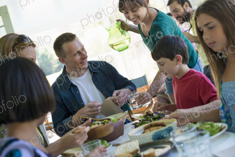 A family party around a table in a cafe. Adults and children.