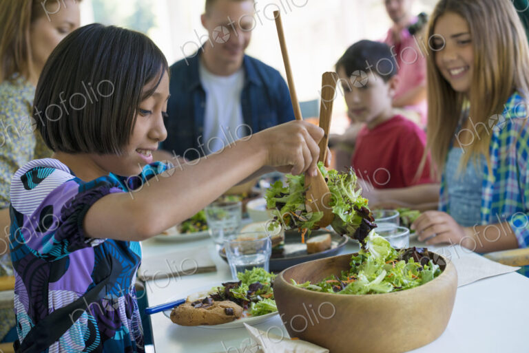 A family party around a table in a cafe. Adults and children.