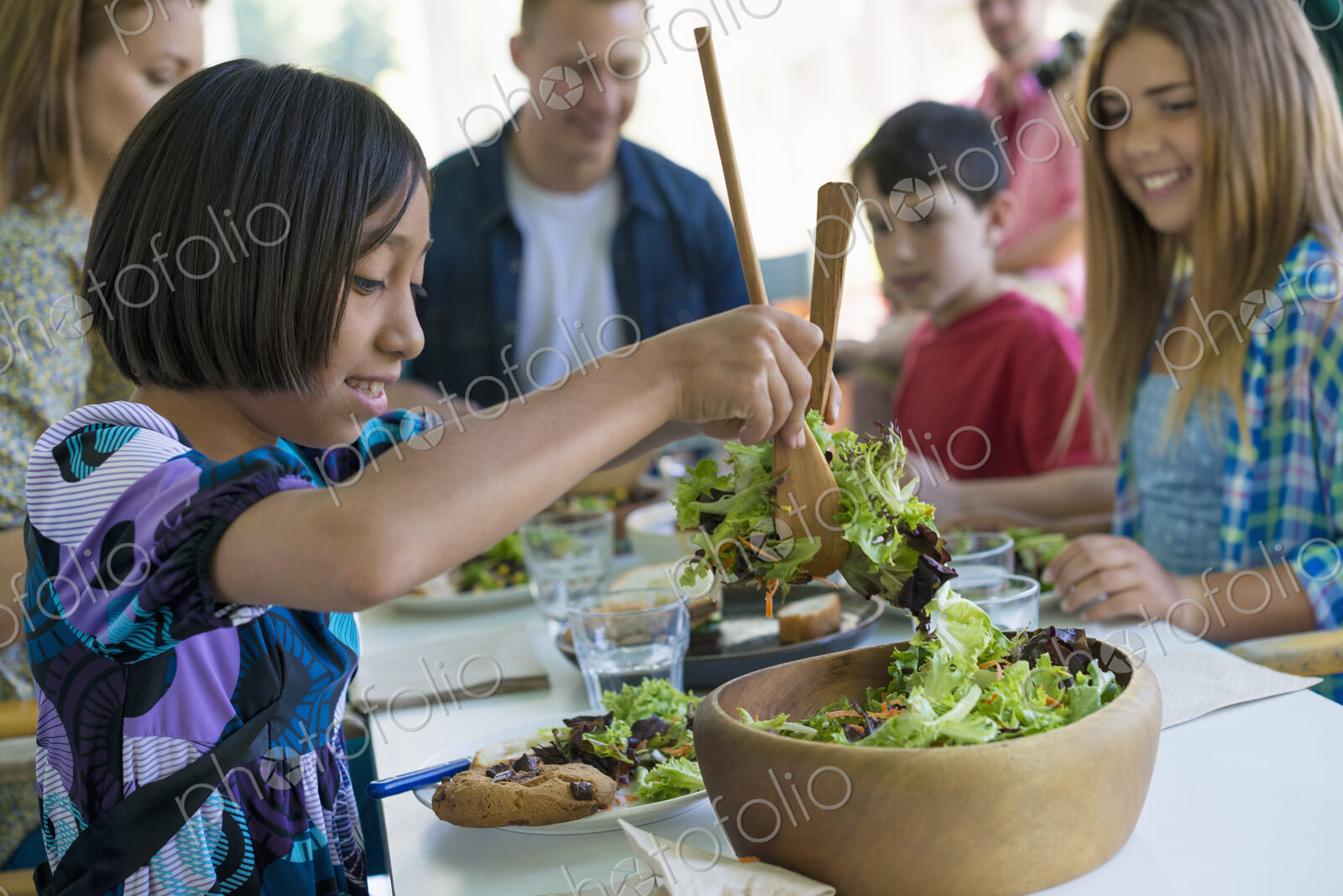 A family party around a table in a cafe. Adults and children.