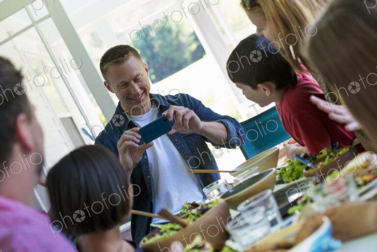 A family party around a table in a cafe. Adults and children.