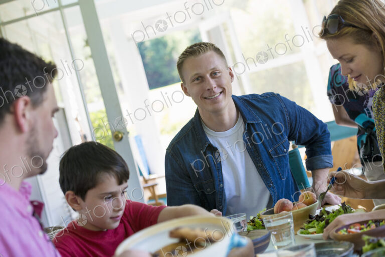 A family party around a table in a cafe. Adults and children.