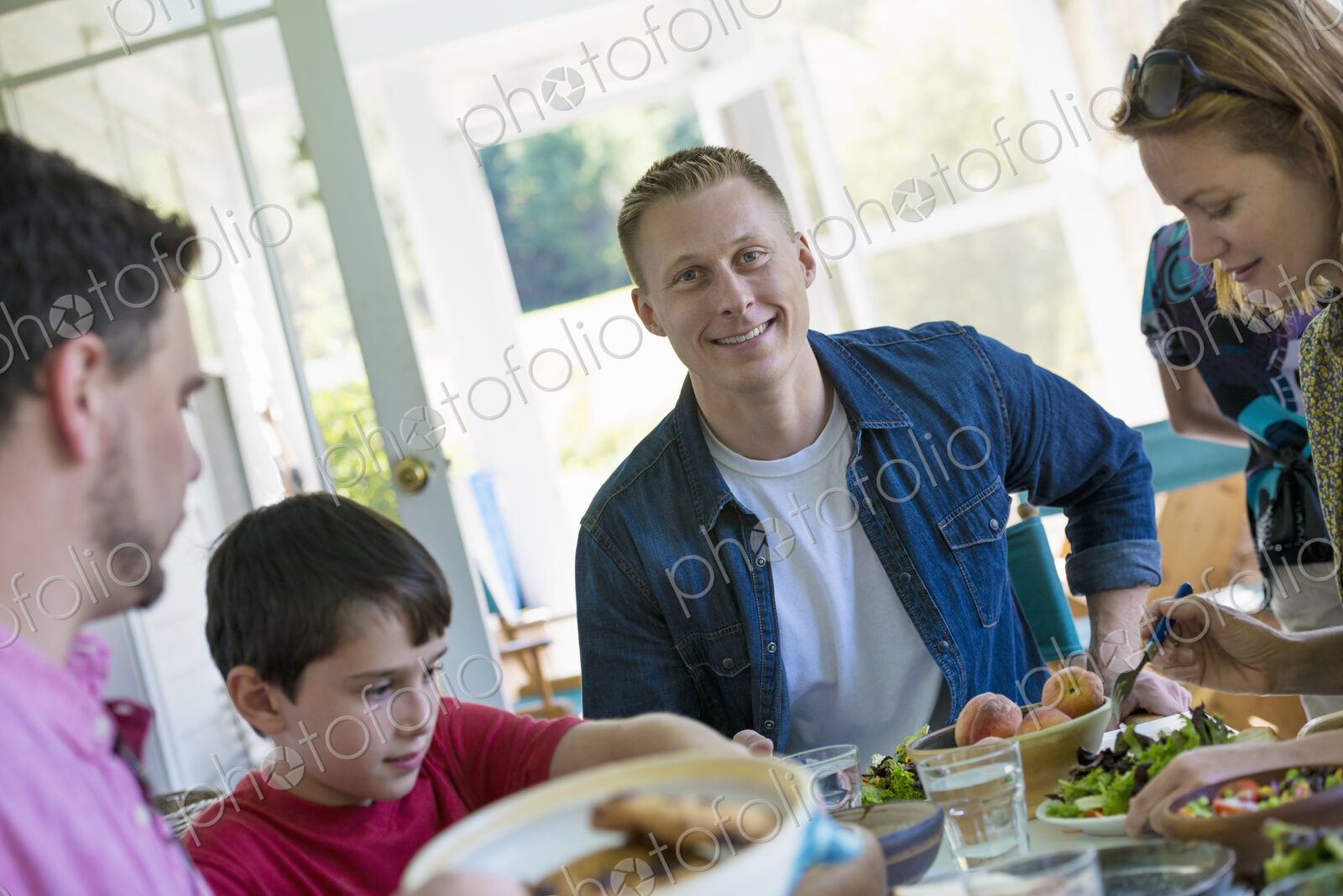 A family party around a table in a cafe. Adults and children.