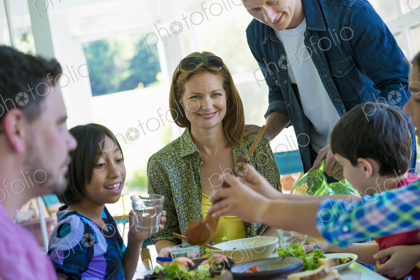 A family party around a table in a cafe. Adults and children.
