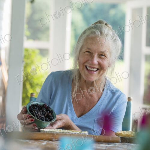 A family party in a farmhouse in the country in New York State. A mature woman holding… A family party in a farmhouse in the country in New York State. A mature woman holding…