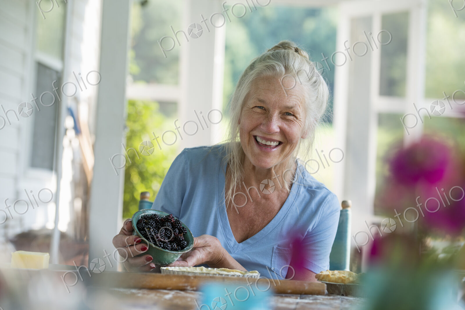 A family party in a farmhouse in the country in New York State. A mature woman holding…