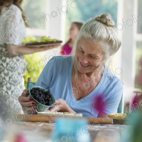 A family party in a farmhouse in the country in New York State. A mature woman holding… A family party in a farmhouse in the country in New York State. A mature woman holding…