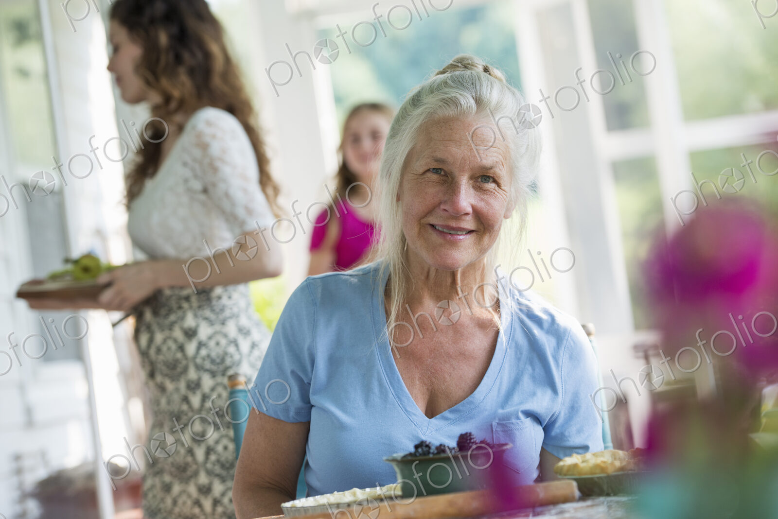 A family party in a farmhouse in the country in New York State. A mature woman holding…