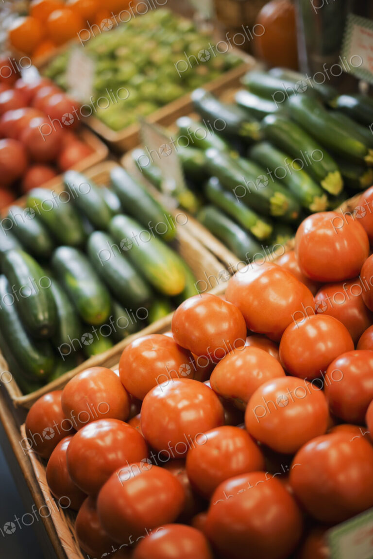 A farm stand display of organic vegetables. Produce. tomatoes and cucumbers.
