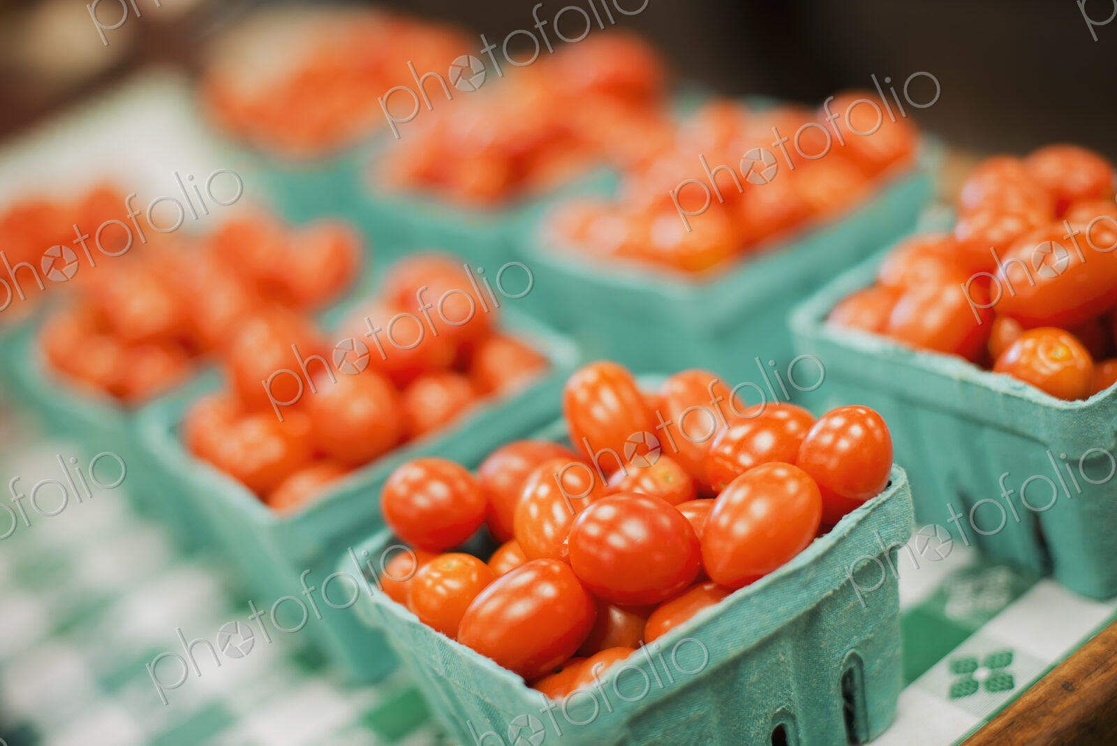A farm stand. Green boxes of tomatoes.