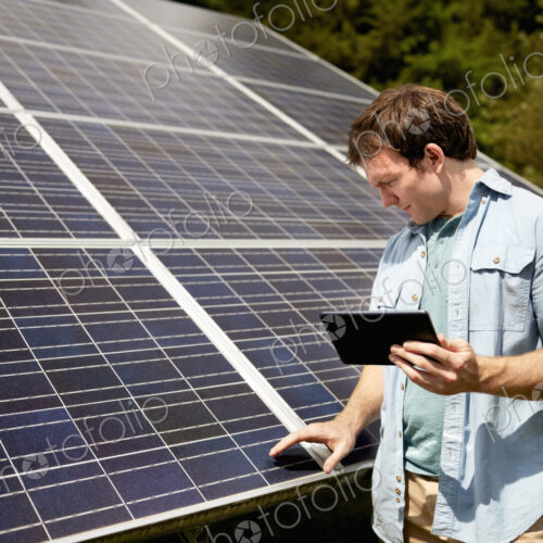 A farmer closely inspecting the surface of a solar panel on the farm.