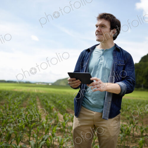 A farmer holding a digital tablet, technology in farming, in his fields in New York… A farmer holding a digital tablet, technology in farming, in his fields in New York…