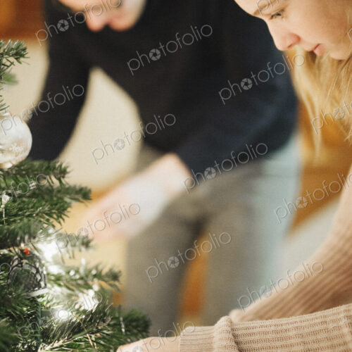 A father and daughter decorating a Christmas tree. A father and daughter decorating a Christmas tree.