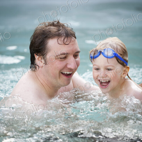A father and son in a swimming pool, swimming. A father and son in a swimming pool, swimming.