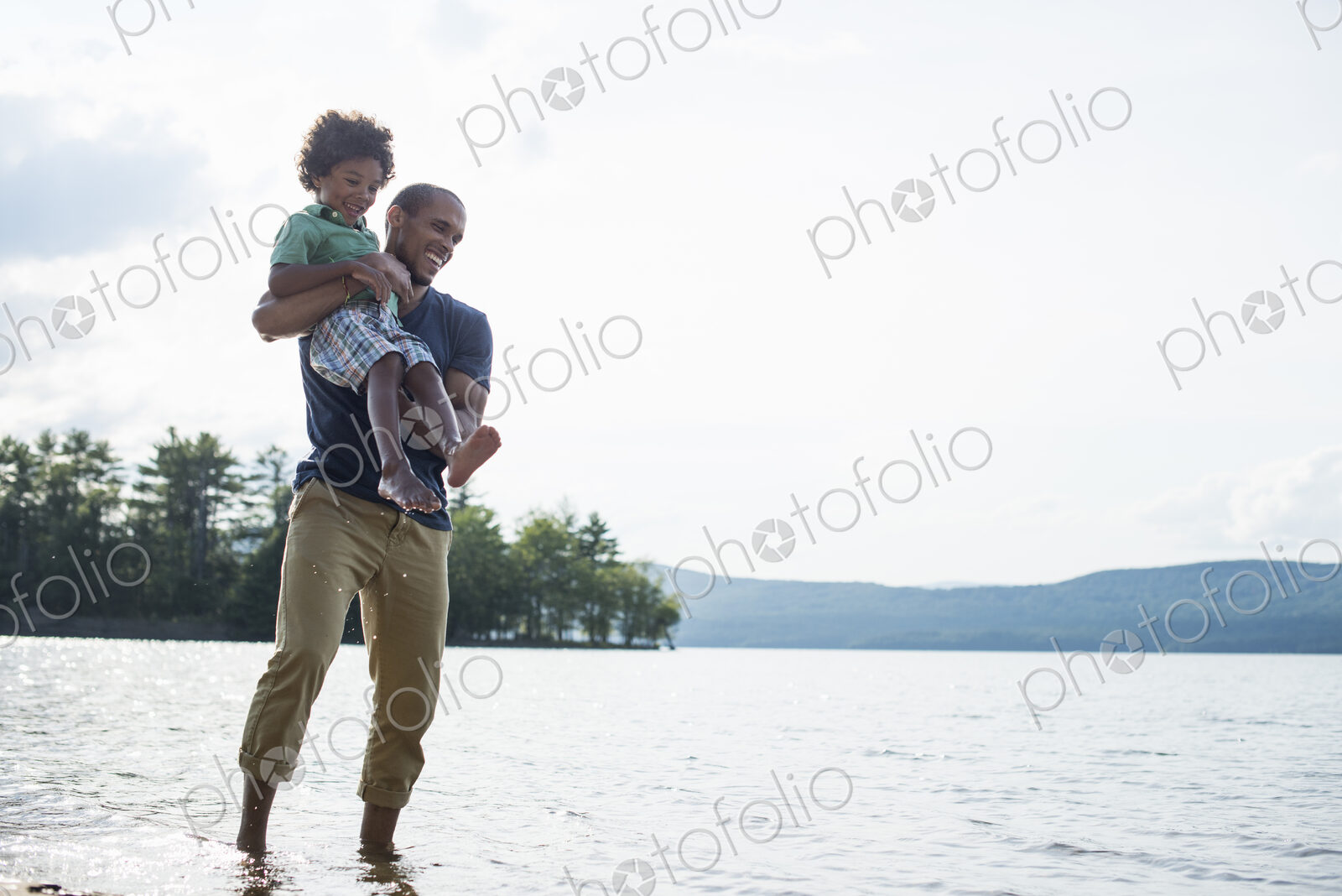 A father and son on a lake shore in summer.