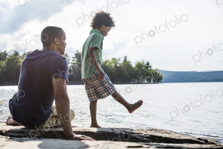 A father and son on a lake shore in summer.