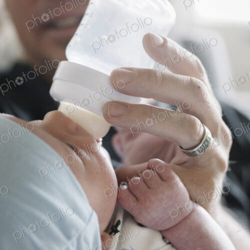 A father cradling a small baby and bottle feeding him. A father cradling a small baby and bottle feeding him.